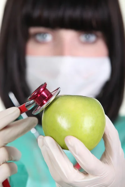 Medic using a stethoscope on an apple — Stock Photo, Image