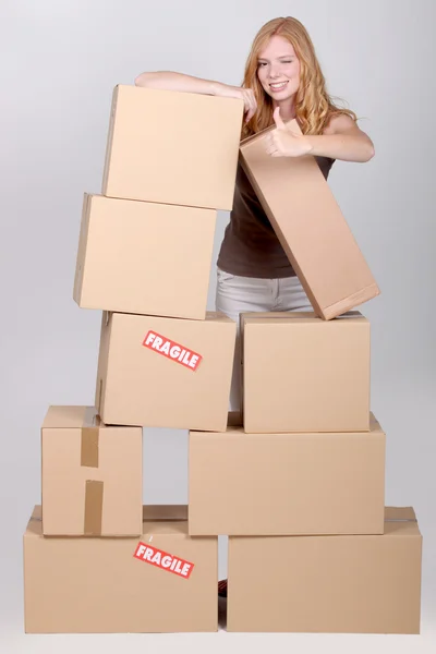 Frau stand neben Stapel Pappkartons — Stockfoto