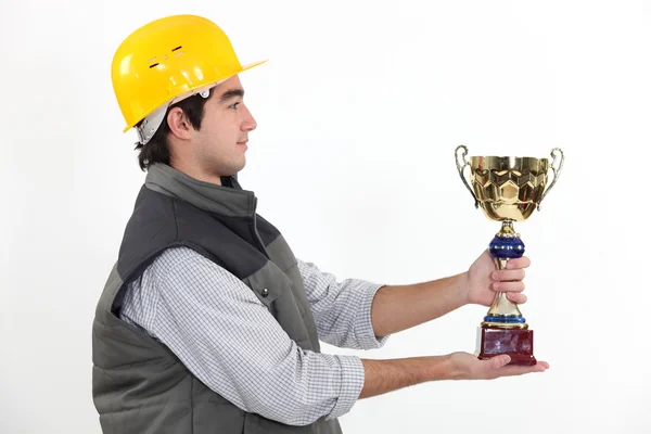 Young craftsman in profile holding trophy — Stock Photo, Image