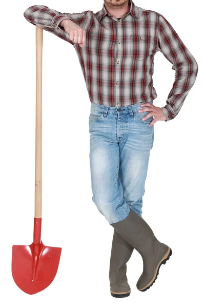 Craftsman leaning on a shovel — Stock Photo, Image