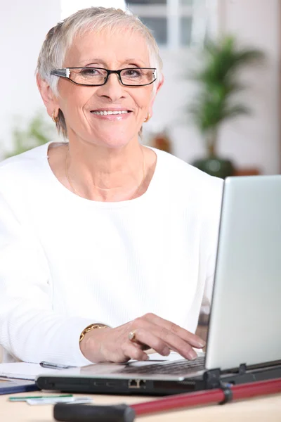 Mujer mayor en el ordenador portátil — Foto de Stock