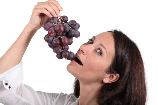 Morena mulher comendo uvas — Fotografia de Stock