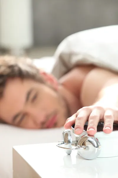 Man turning of his alarm clock — Stock Photo, Image