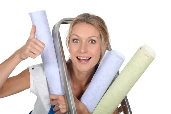 Mujer parada junto a la escalera sosteniendo huellas azules — Foto de Stock