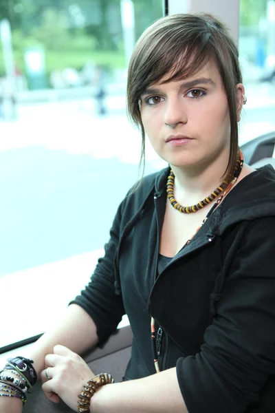 Funky mladá žena sedící na tramvaj — Stock fotografie