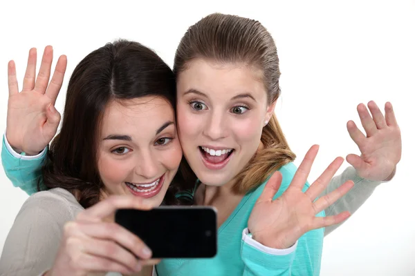 Duas meninas posando com telefone da câmera — Fotografia de Stock