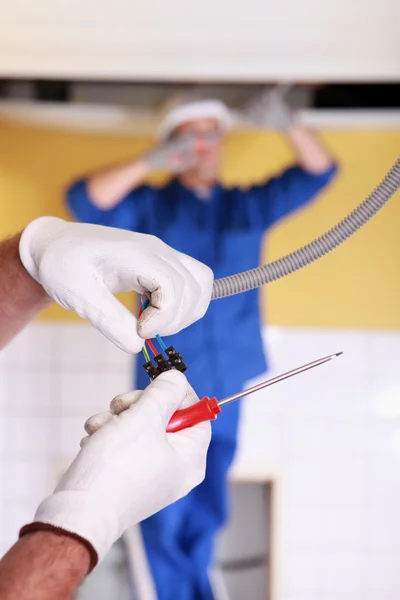 Two electrician repairing ceiling lighting — Stock Photo, Image