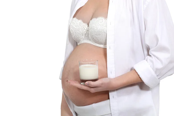Беременная женщина держит стакан молока — стоковое фото