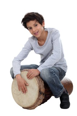 Young boy playing the djembe clipart
