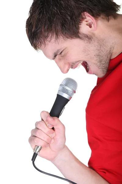 Человек поет в микрофон — стоковое фото