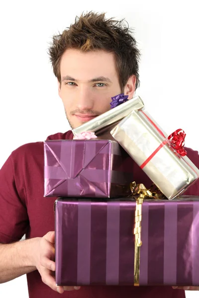 Hombre sosteniendo pila de regalos — Foto de Stock