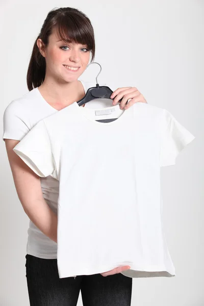 Chica con una camiseta blanca en una percha — Foto de Stock