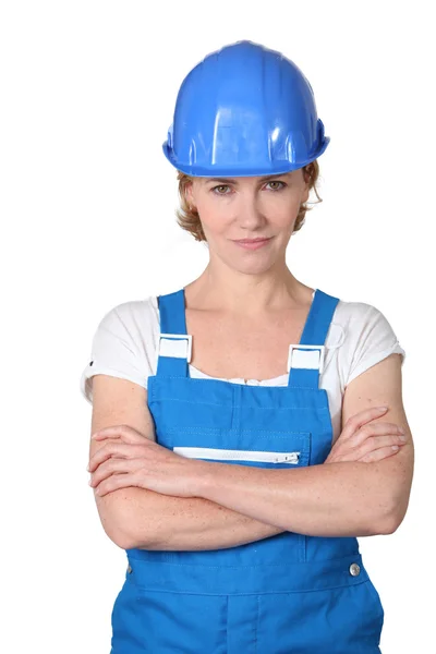 Vrouw die draagt blauwe werk overall en hard hat — Stockfoto