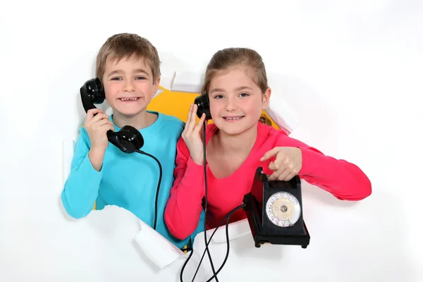 Brother and sister with old-fashioned telephone Stock Photo