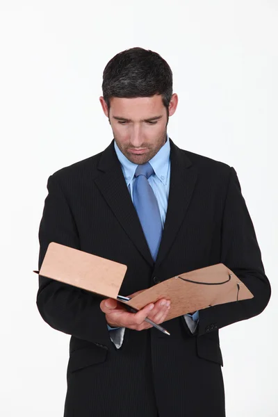 Joven empresario leyendo el contenido de la carpeta — Foto de Stock