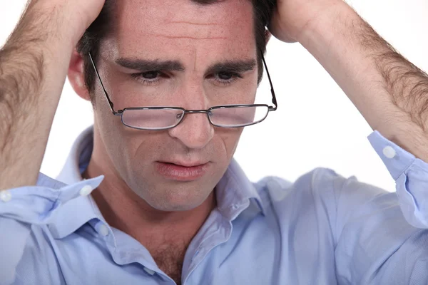 Hombre con gafas bajadas en la nariz mirando molesto — Foto de Stock