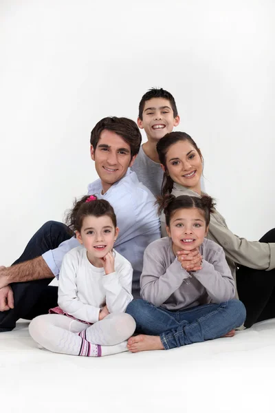 Föräldrar och tre barn satt tillsammans — Stockfoto