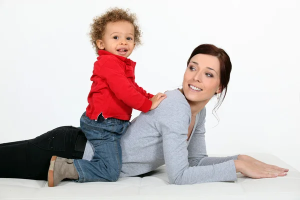 Little boy on his mother back. — Stock Photo, Image