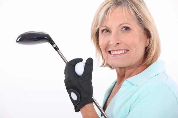Mature blonde woman taking golf club and golf ball — Stock Photo, Image