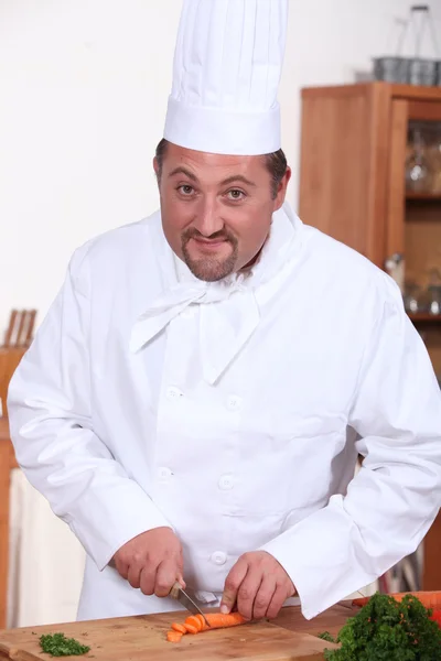 Jefe de cocina hinchado cortar zanahorias en casa —  Fotos de Stock