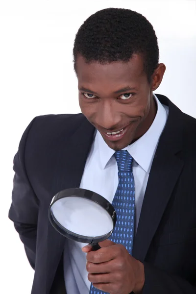 Businessman using magnifying glass — Stok fotoğraf