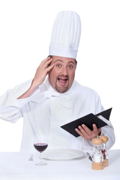 Cozinheiro sem pistas sentado a uma mesa — Fotografia de Stock