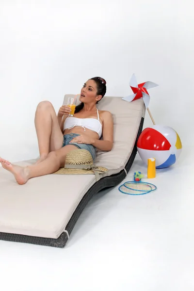 Mulher atraente deitada em uma cadeira lounge na praia — Fotografia de Stock