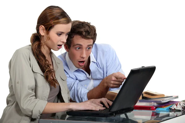 震惊的夫妇指着一台笔记本电脑 — 图库照片
