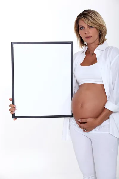 Pregnant women holding picture frame — Stock Photo, Image
