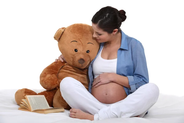 Mulher grávida sentou-se com grande ursinho — Fotografia de Stock