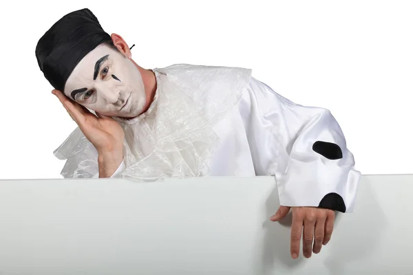 Homme en costume Pierrot avec une planche prête pour votre texte — Photo