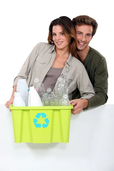 Pareja sonriente clasificando basura sobre fondo blanco —  Fotos de Stock