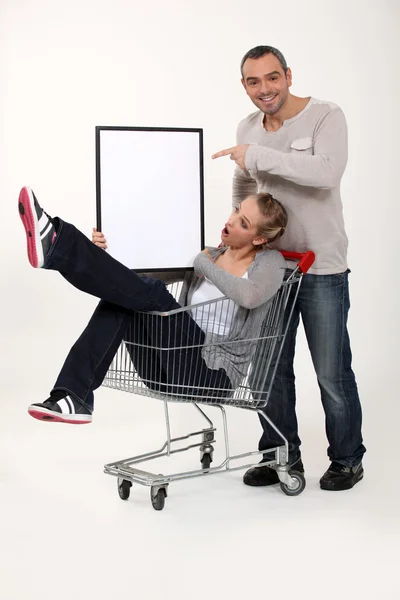 トロリーをショッピングと遊び心のあるカップル — ストック写真
