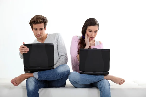 Casal jovem com seus laptops — Fotografia de Stock