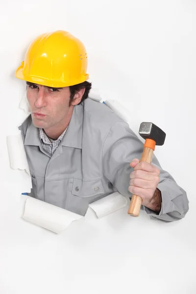 Carpenter with hammer against torn paper background — Stock Photo, Image