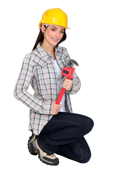 Feminino construtor brandindo chave ajustável — Fotografia de Stock