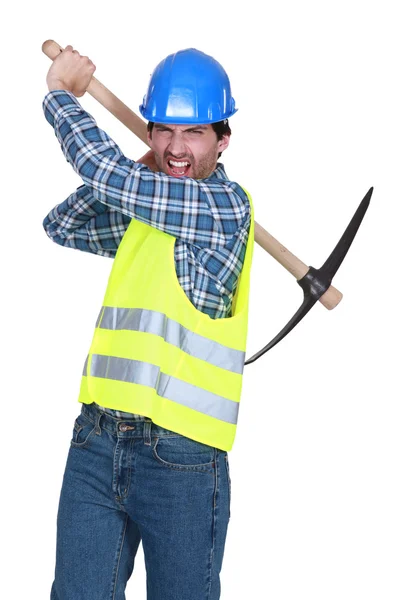 Trabalhador agressivo segurando uma picareta — Fotografia de Stock