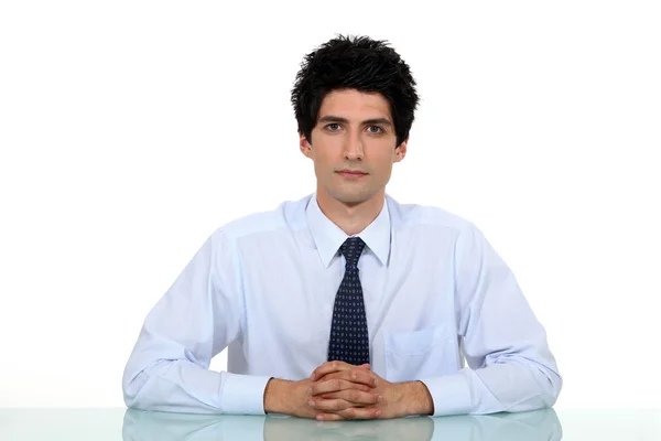 Man i en kostym och slips sitter vid ett skrivbord — Stockfoto