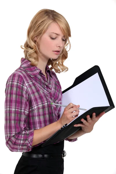 Mujer atractiva escribiendo en una carpeta — Foto de Stock