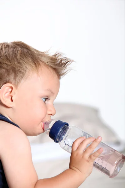 Schattige babyjongen met fles — Stockfoto