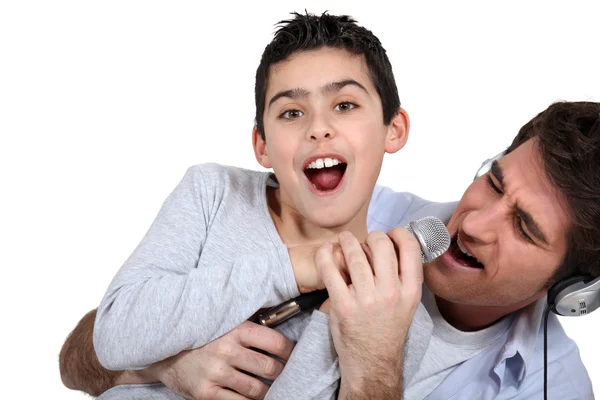 Padre e figlio cantano in un microfono — Foto Stock