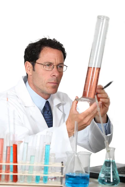 Técnico de laboratório examinando líquido em um cilindro graduado — Fotografia de Stock