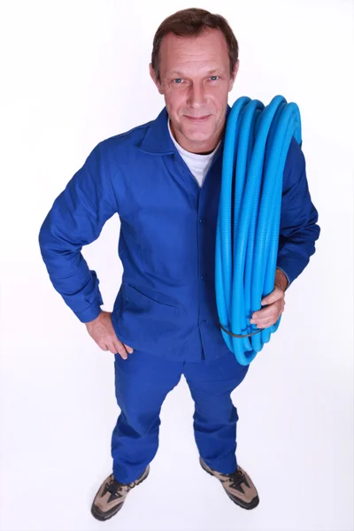 Encanador com um carretel de tubo azul — Fotografia de Stock