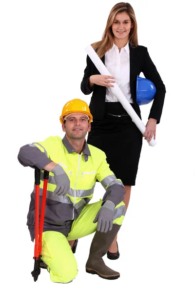 Mulher profissional de pé ao lado de um trabalhador de colarinho azul — Fotografia de Stock