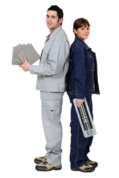 Homem e mulher segurando telhas e cortador — Fotografia de Stock