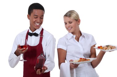 A wine waiter showing a bottle to a waitress clipart