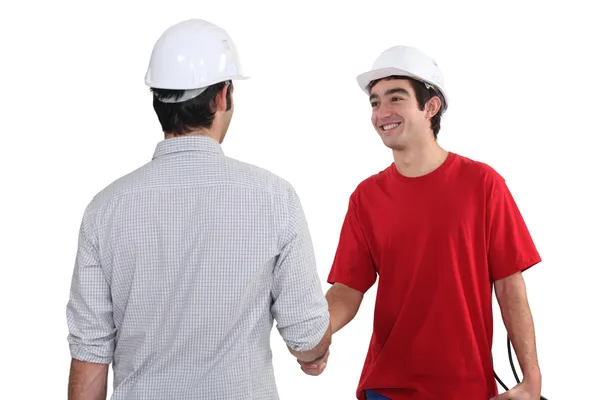 Trabajadores de la construcción estrechando manos — Foto de Stock