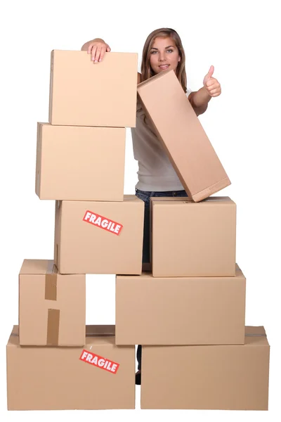 Žena za hromadu kartonových krabic — Stock fotografie