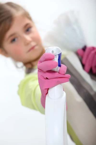 Weinig meisje sproeien schoonmakende product — Stockfoto