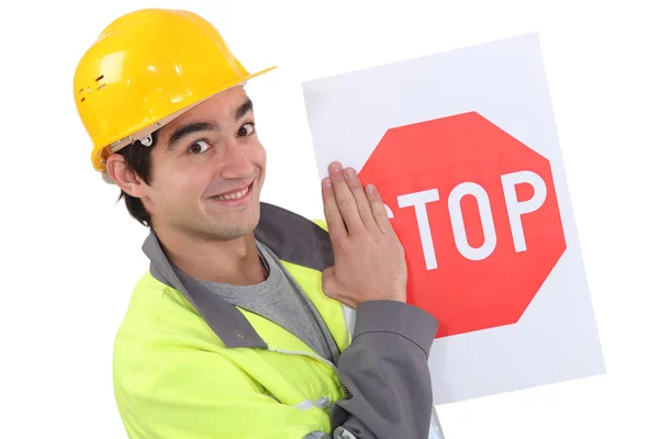 Молодой дорожный рабочий держит знак "Стоп" . — стоковое фото